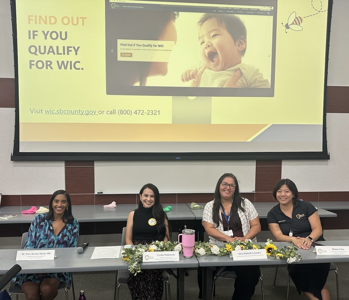 Melody seated on a panel during a local community event.